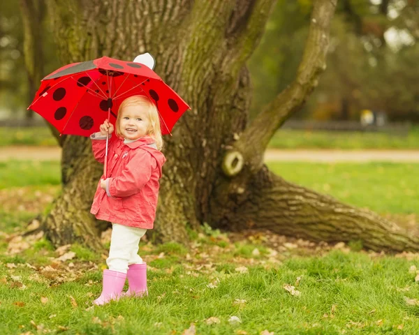 Szczęśliwe dziecko z czerwony parasol na zewnątrz — Zdjęcie stockowe