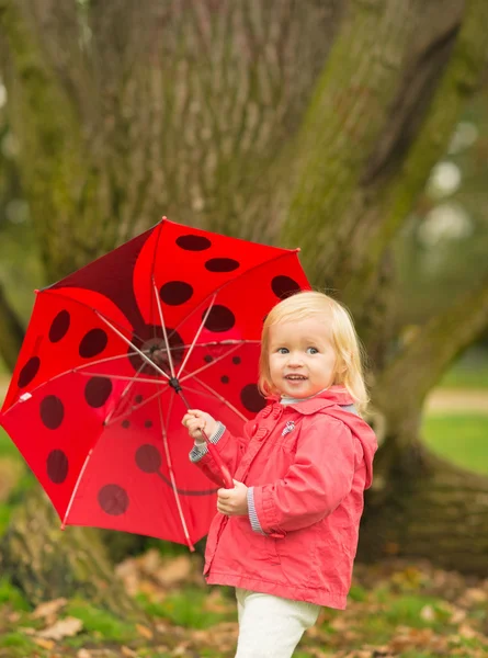 Kırmızı şemsiye açık havada birlikte mutlu bebek portresi — Stok fotoğraf