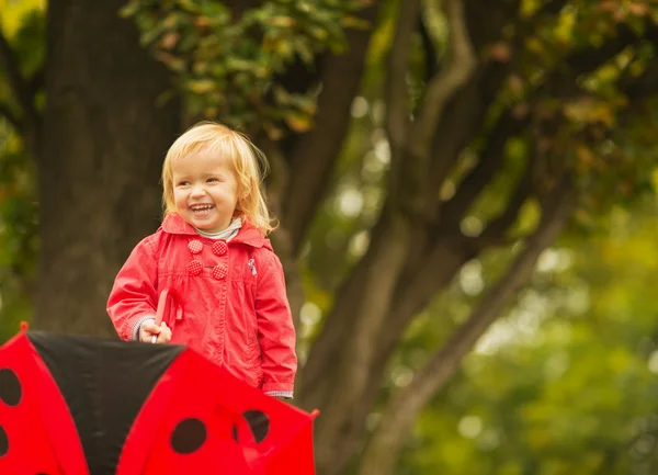 Portrét smějící se dítě s červeným deštníkem — Stock fotografie