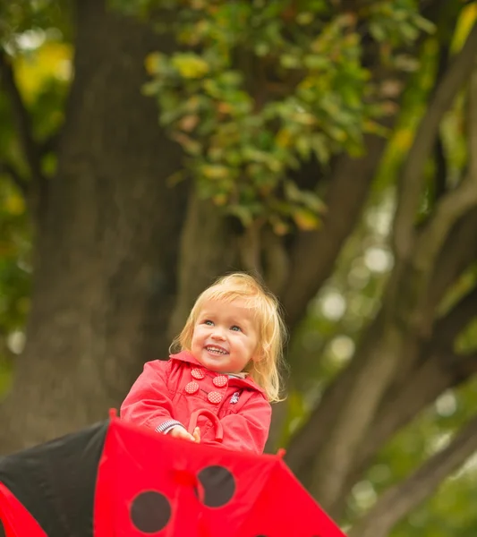 Portret van lachen baby met rode paraplu opzoeken — Stockfoto