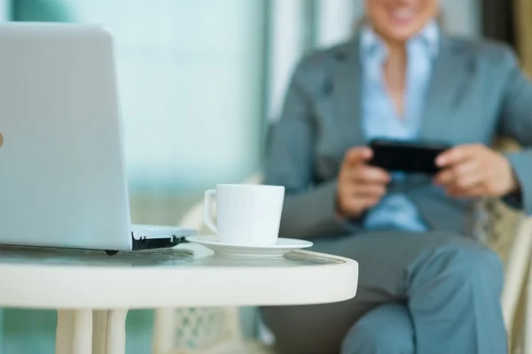 Närbild på bord med laptop och business kvinna i bakgrunden — Stockfoto