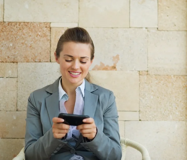 Glückliche Geschäftsfrau schreibt SMS auf Handy — Stockfoto