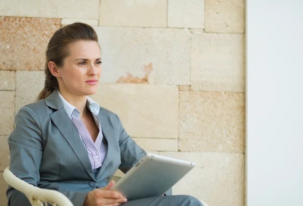 Business woman holding tablet PC and looking on copy space — Stock Photo, Image