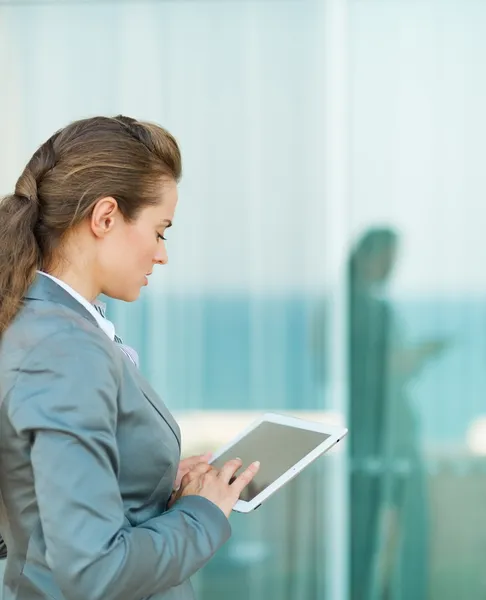 Бизнес-леди смотрит в планшетный компьютер — стоковое фото