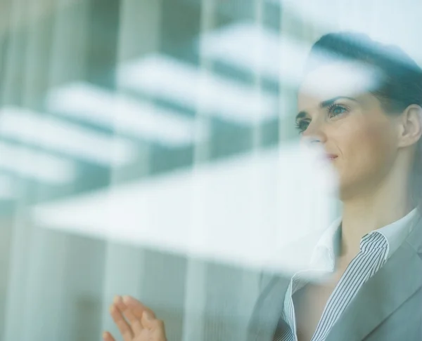 Portrait of business woman looking in window — Stock Photo, Image