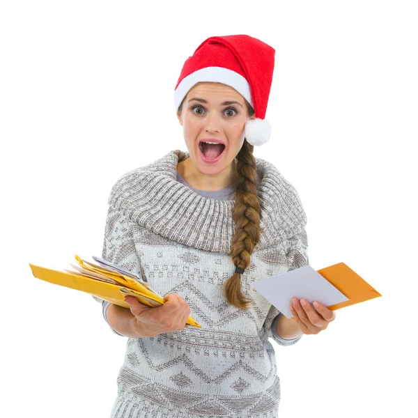Shocked woman in Santa hat surprised by lots of Christmas letter Stock Photo