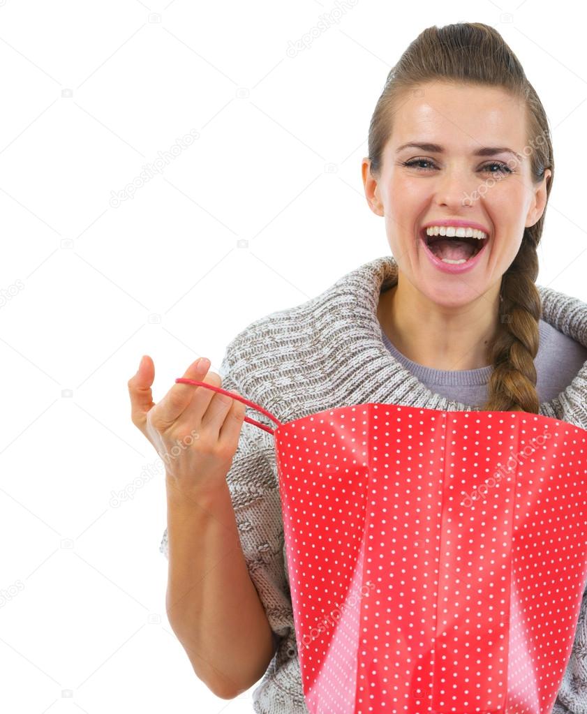Smiling woman in sweater opening shopping bag