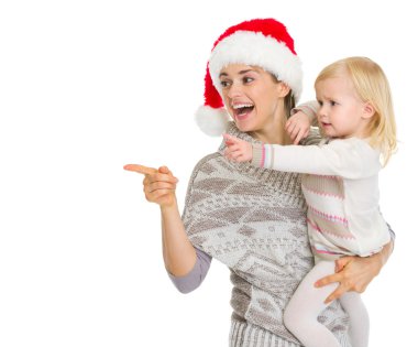 kopya s işaret Noel şapka ve bebek kız annesi gülümseyerek