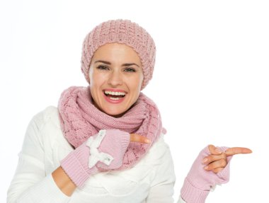 gülümseyen kadın örgü atkı içinde kopyalamak şapka ve eldiven üzerinde işaret eden sp