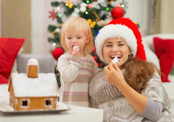 Gelukkig moeder en baby eten kerstkoekjes — Stockfoto