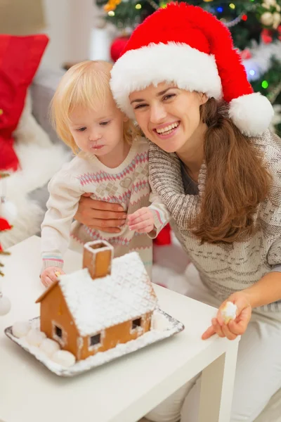 Portrait of smiling mother and baby near Christmas Gingerbread h — Stock Photo, Image