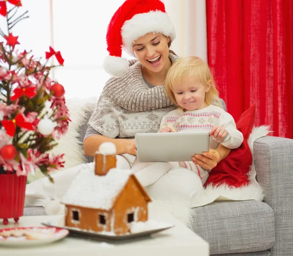 Madre mostrando bambino qualcosa in tablet PC vicino all'albero di Natale — Foto Stock