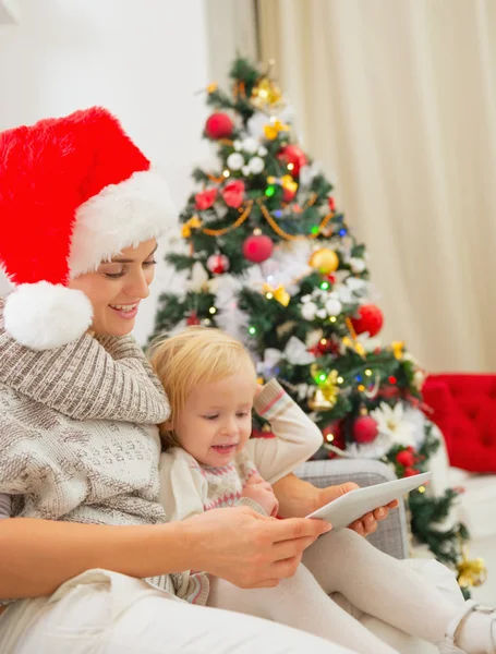 Boldog anya és a gyerek segítségével tablet Pc karácsonyfa közelében — Stock Fotó