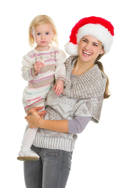 Weihnachtsporträt einer glücklichen Mutter und eines Plätzchen essenden kleinen Mädchens — Stockfoto