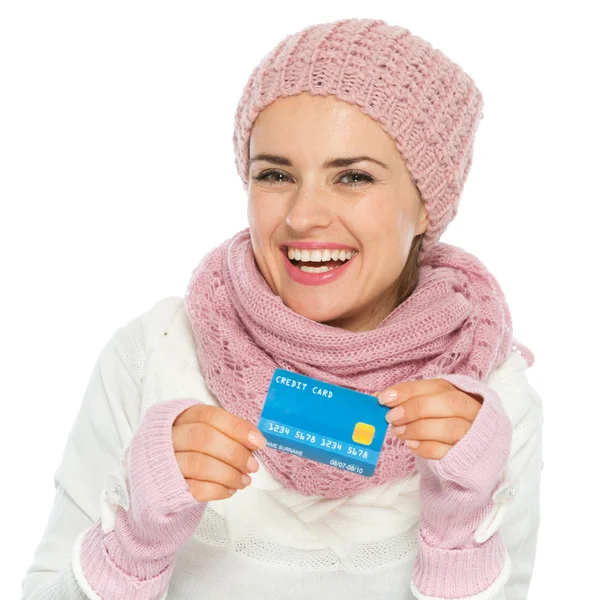 Lachende vrouw in gebreide sjaal, muts en wanten met creditcard — Stockfoto