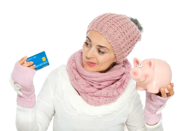 Verward vrouw in brei winter kleding bedrijf credit card en p — Stockfoto