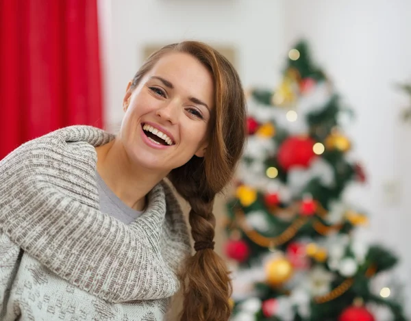 Portret van gelukkige jonge vrouw voor kerstboom — Stockfoto