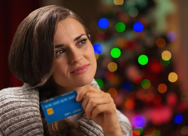 Portrait de femme réfléchie avec carte de crédit devant le Christ — Photo