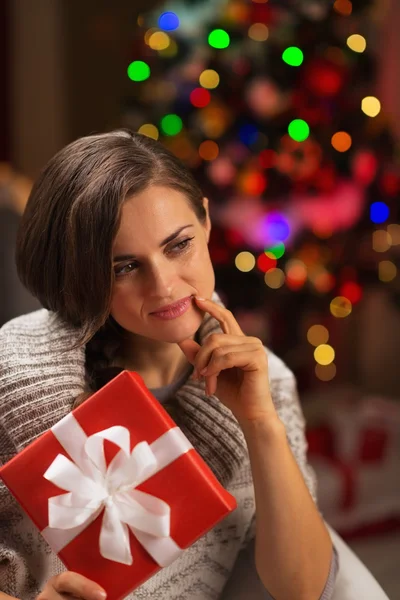 Mujer joven reflexiva con caja de regalo de Navidad — Foto de Stock