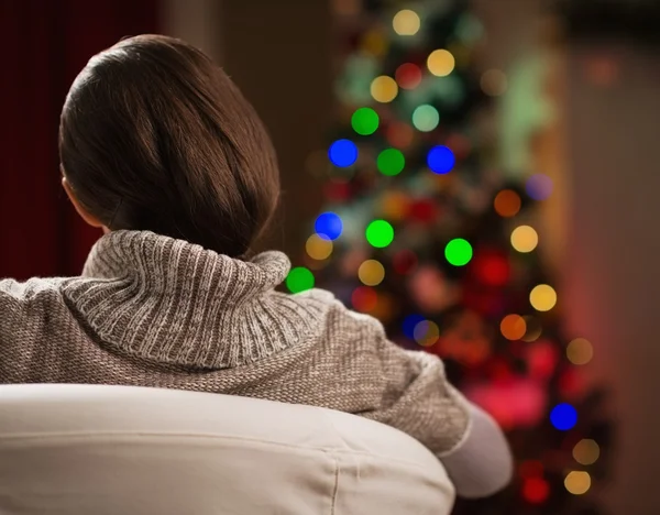 Jovem mulher olhando na árvore de Natal. Vista traseira — Fotografia de Stock