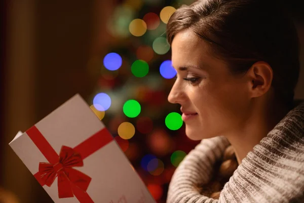 Jeune femme lisant carte postale de Noël — Photo