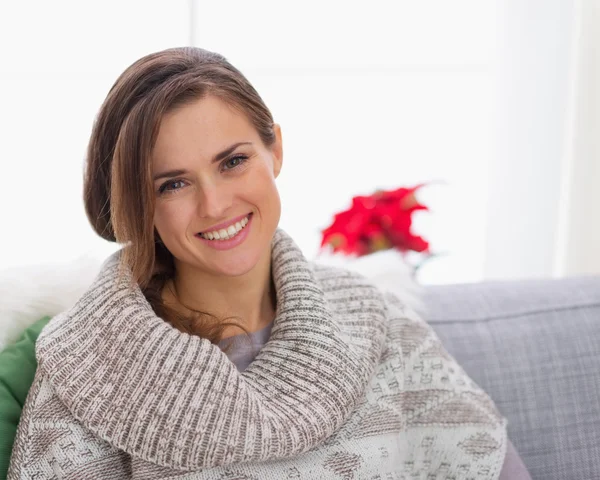 Portrait of smiling woman in knit sweater sitting on couch — Stock Photo, Image