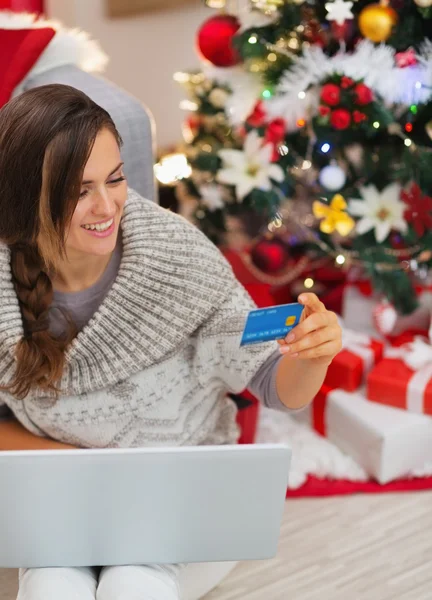ノート パソコンとクリスマス ツリーの近くのクレジット カードと笑顔の女性 — ストック写真