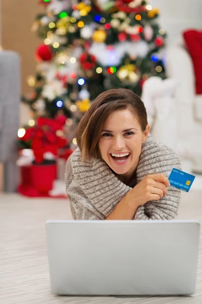 Mosolygó nő laptop, és a karácsonyfa közelében hitelkártya — Stock Fotó