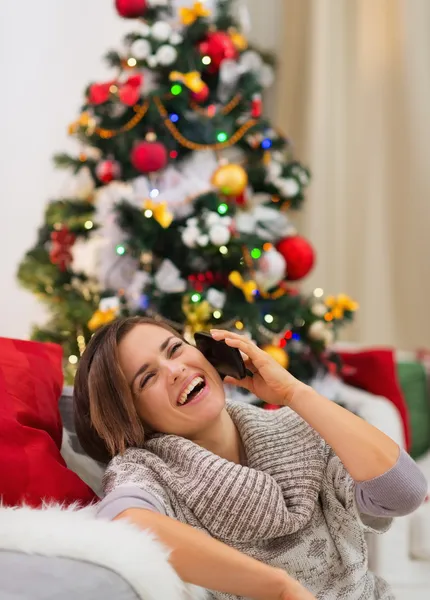 Leende ung kvinna tala mobil nära julgran — Stockfoto