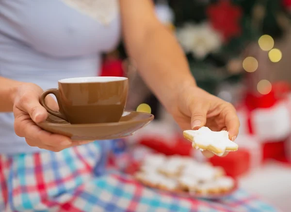 Närbild på kvinnan i pyjamas hålla varma drycker och kakor i — Stockfoto