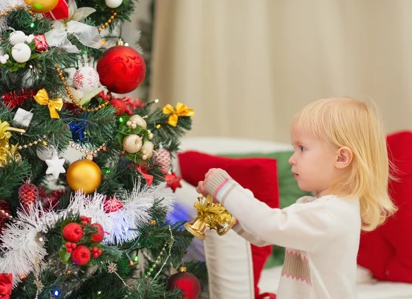 Baby decorating Christmas tree Stock Photo