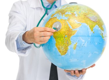 Closeup on medical doctor woman listening globe with stethoscope clipart