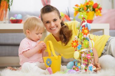 Baby playing with Easter decorations clipart