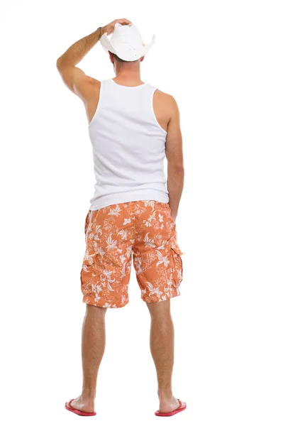 Retrato de comprimento total de homem jovem em shorts e chapéu. vista traseira — Fotografia de Stock