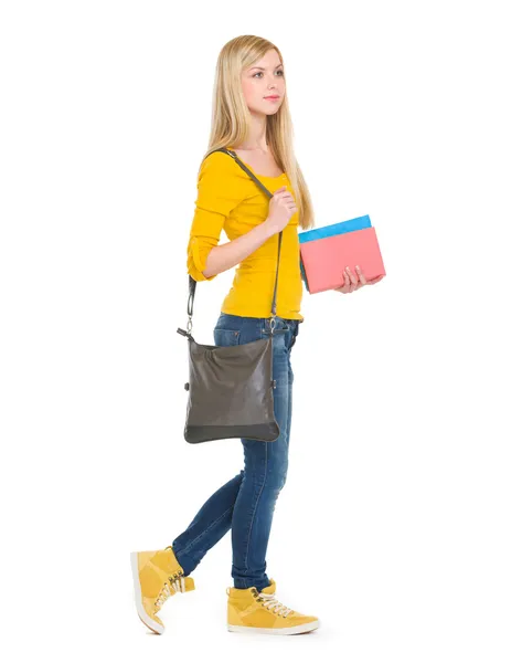 Teenage student girl with books going sideways — Stock Photo, Image