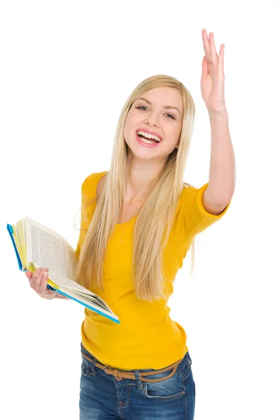 Chica estudiante feliz con libro levantando la mano para responder —  Fotos de Stock