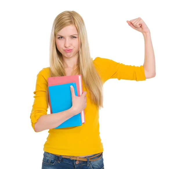 Happy student girl with book showing biceps — Stock Photo, Image