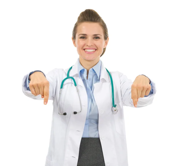 Sorrindo médico mulher apontando para baixo — Fotografia de Stock