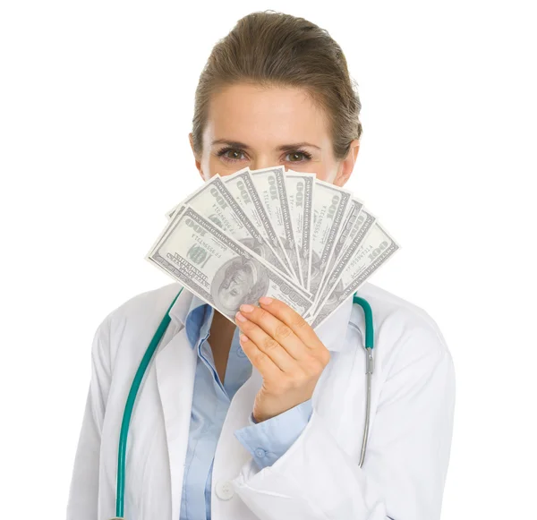 Medical doctor woman hiding behind fan of dollars — Stock Photo, Image