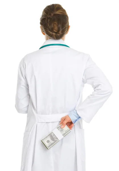 Médico médico mujer ocultando paquete de dólares detrás de la espalda — Foto de Stock