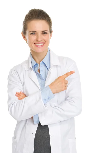 Happy medical doctor woman pointing on copy space — Stock Photo, Image