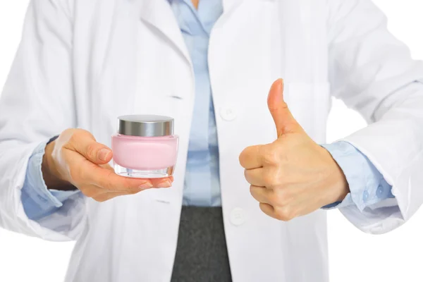 Cosmetist woman showing creme and thumbs up — Stock Photo, Image