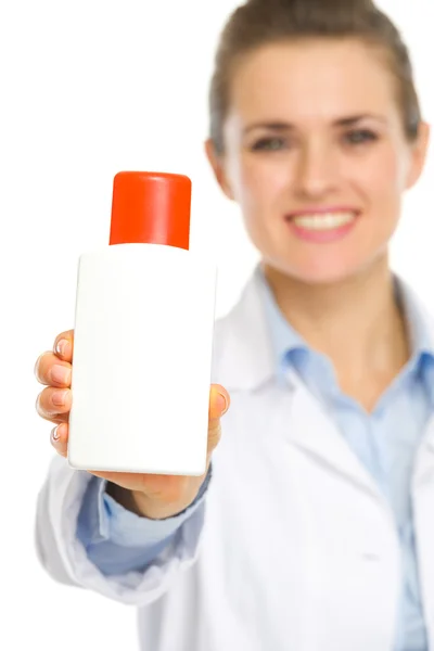 Closeup on bottle of sunscreen in hands of cosmetologist — Stock Photo, Image