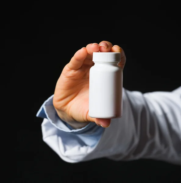 Fechar a mão com frasco de medicamento isolado — Fotografia de Stock