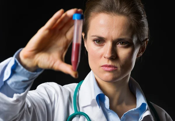 Medical doctor woman looking on test tube with blood isolated — Stock Photo, Image