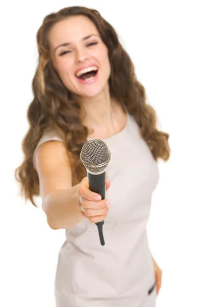 Jonge vrouw uitrekken microfoon in de camera — Stockfoto