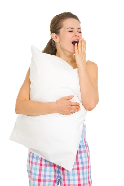 Young woman in pajamas with pillow yawing — Stock Photo, Image