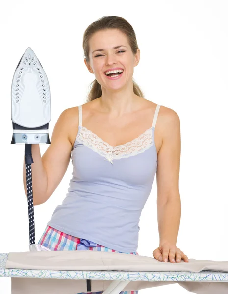 Young woman in pajamas with iron — Stockfoto