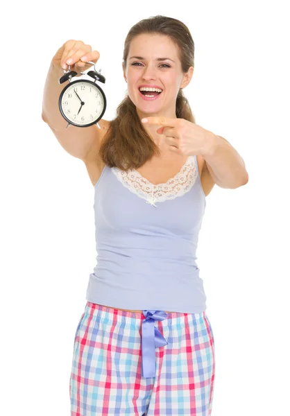 Young woman in pajamas looking on alarm clock — Stock Photo, Image