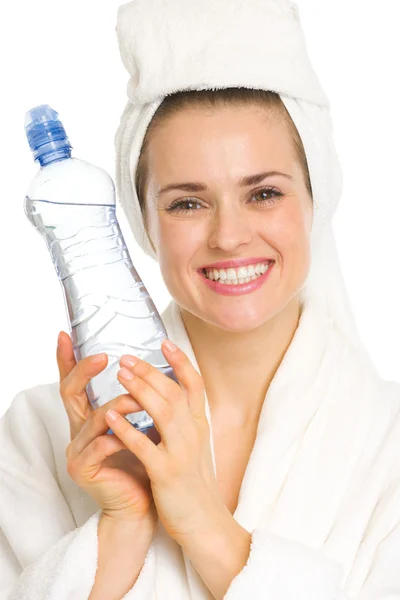 Jonge vrouw in badjas met water fles — Stockfoto